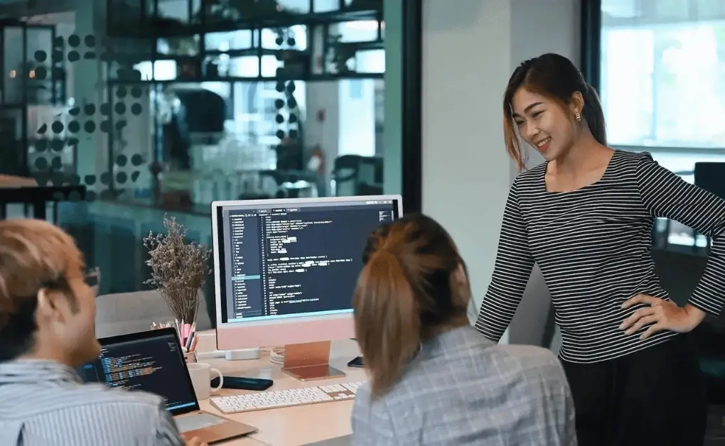 Female developer leading a team coding discussion for outsourcing software development to the Philippines